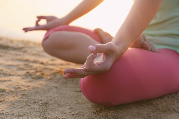 Giovane bella donna meditando yoga sulla spiaggia da vicino