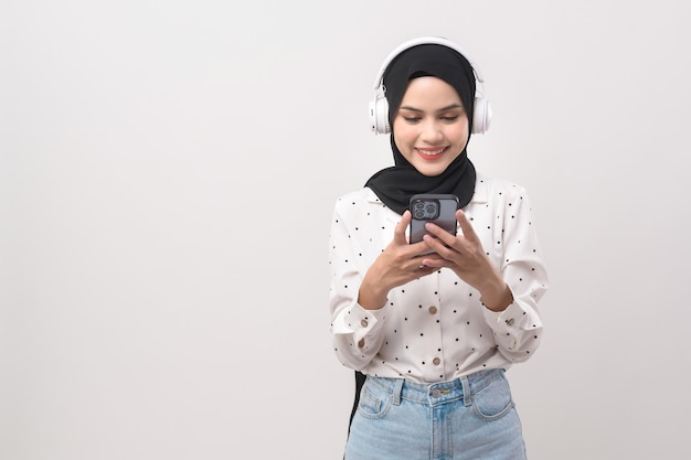 Giovane bella donna musulmana che indossa la cuffia su sfondo bianco