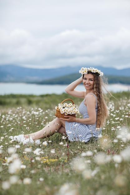 giovane bella donna nel campo della camomilla