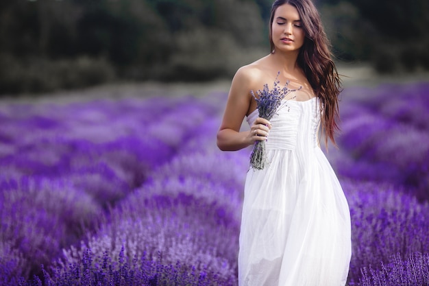 Giovane bella donna nel giacimento della lavanda. Signora su sfondo estivo