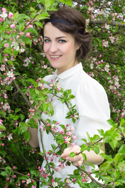 giovane bella donna nel giardino di fioritura primaverile