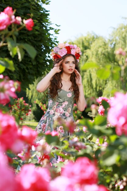 Giovane bella donna nel giardino fiorito