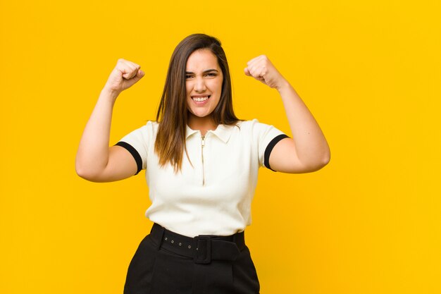 Giovane bella donna sentirsi felice, positivo e di successo, celebrando la vittoria