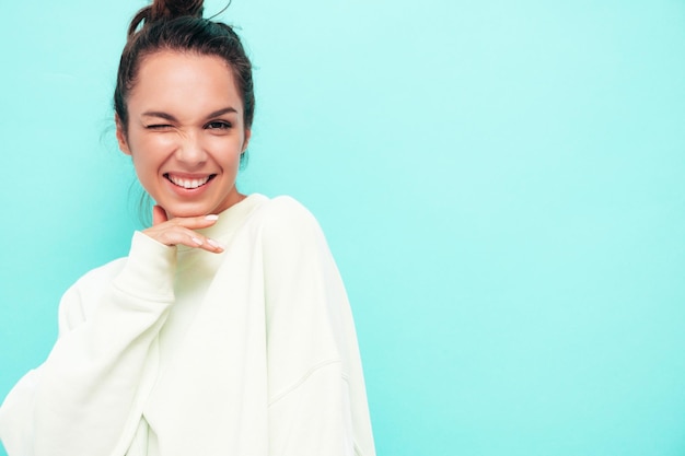 Giovane bella donna sorridente in abiti estivi alla moda donna spensierata in posa vicino al muro in studio Modello bruna positivo divertendosi Allegro e felice