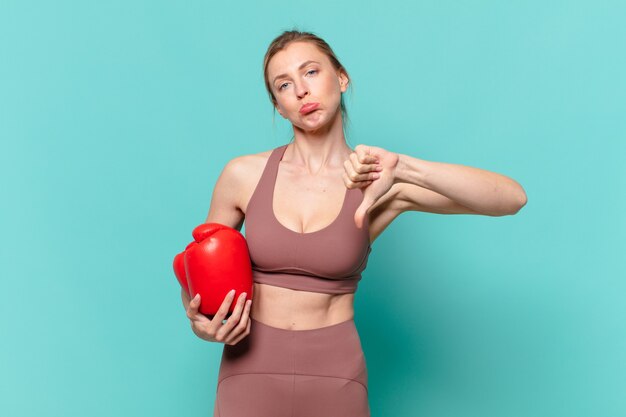 Giovane bella donna sportiva espressione triste e boxe