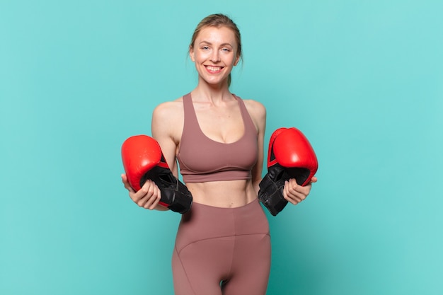 Giovane bella donna sportiva felice espressione e boxe