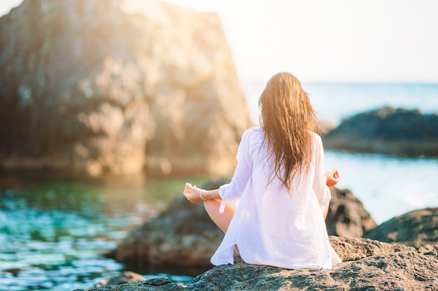 Giovane bella donna su yoga sulla spiaggia