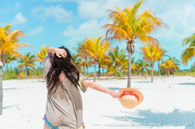 Giovane bella donna sulla spiaggia tropicale della sabbia bianca