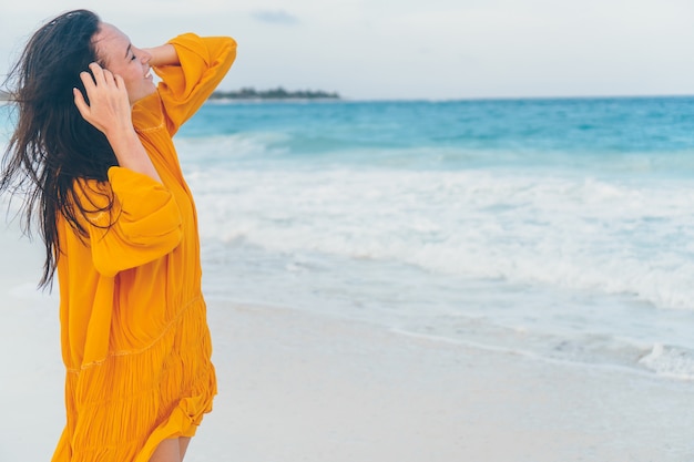 Giovane bella donna sulla spiaggia tropicale nel tramonto.