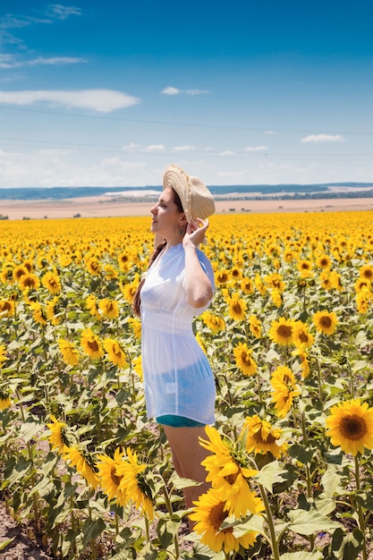 Giovane bella donna tra i girasoli