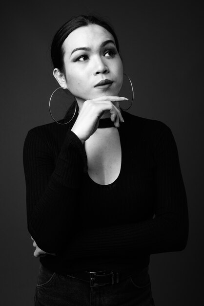 Giovane bella donna transgender asiatica che pensa in bianco e nero