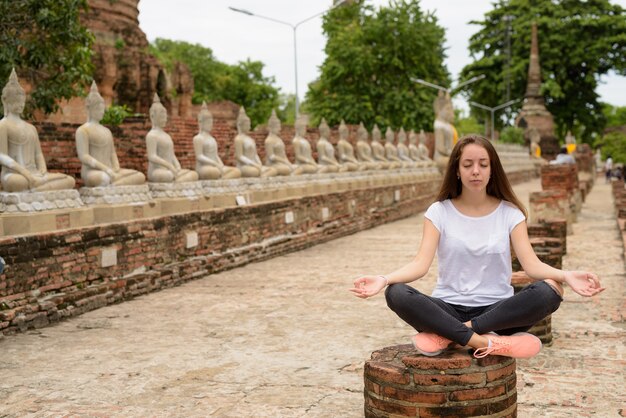 Giovane bella donna turistica che ha vacanza in Ayutthaya, tailandese