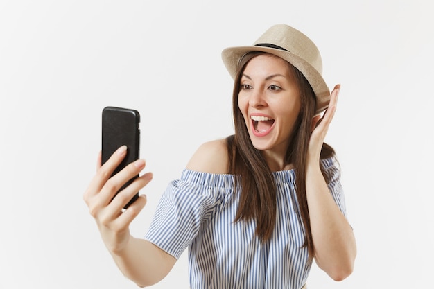 Giovane bella donna vestita vestito blu, cappello facendo selfie girato sul telefono cellulare o videochiamata isolato su sfondo bianco. Persone, emozioni sincere, concetto di stile di vita. Zona pubblicità. Copia spazio.