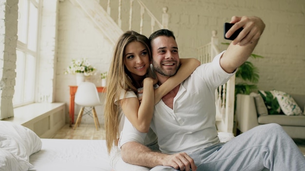 Giovane bella e amorevole coppia scatta foto selfie sulla fotocamera dello smartphone