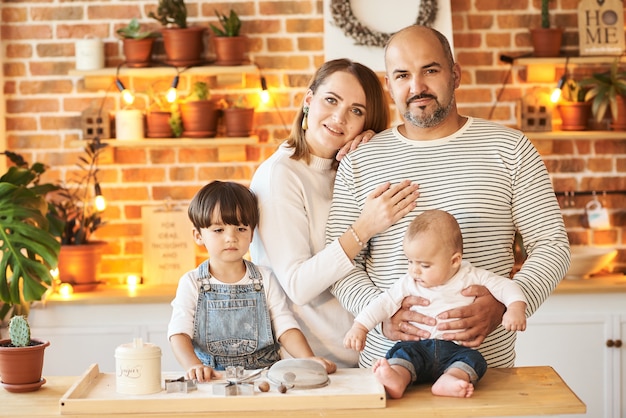 Giovane bella famiglia divertendosi e cucinando nella cucina soleggiata