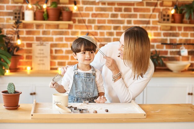 Giovane bella famiglia divertendosi e cucinando nella cucina soleggiata