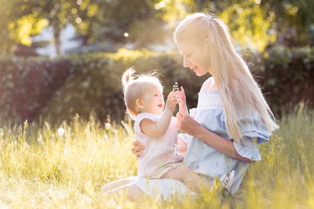 Giovane bella madre bionda con la sua bambina che ride insieme