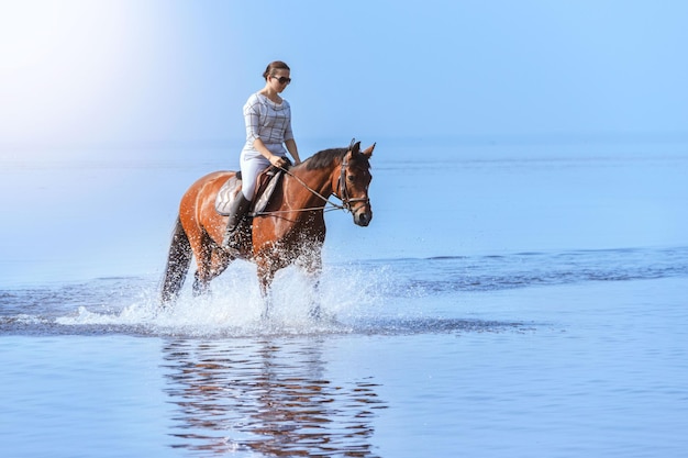 Giovane bella ragazza a cavallo sull'allenamento di sport acquatici