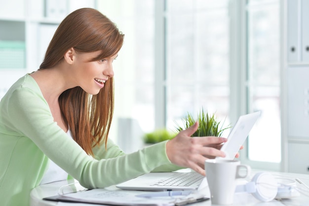 Giovane bella ragazza che lavora a un laptop