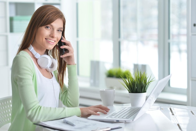 Giovane bella ragazza che lavora ad un computer portatile