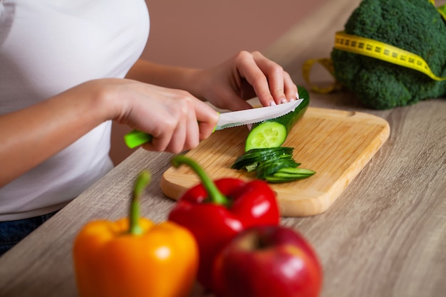 Giovane bella ragazza che prepara l'insalata sana di dieta