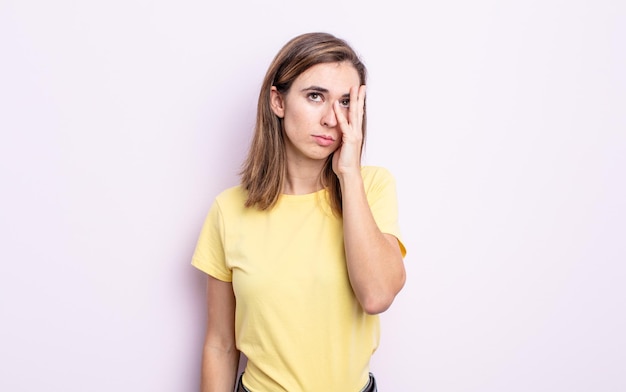 giovane bella ragazza che si sente annoiata, frustrata e assonnata dopo un compito noioso, noioso e noioso, tenendo il viso con la mano