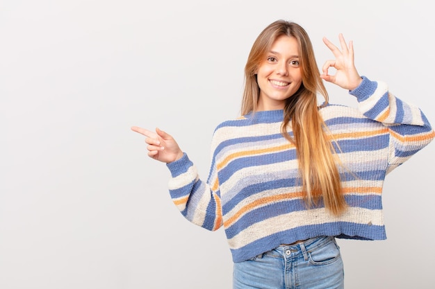 Giovane bella ragazza che si sente felice, mostra approvazione con un gesto ok