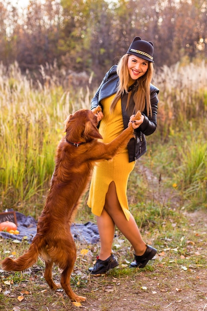 Giovane bella ragazza con un labrador retriever in un parco autunnale