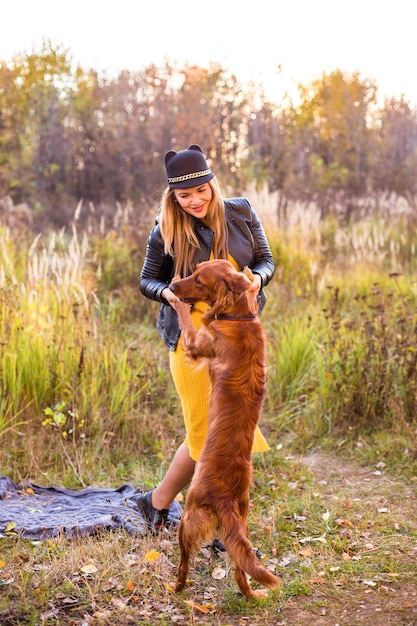 Giovane bella ragazza con un labrador retriever in un parco autunnale