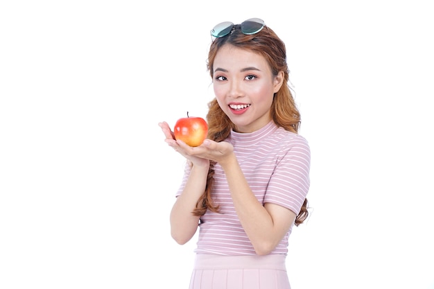 Giovane bella ragazza graziosa in buona salute asiatica con la mela rossa