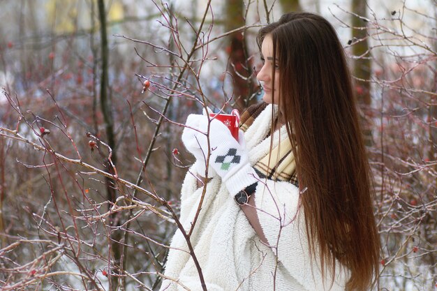 Giovane bella ragazza in inverno nevoso giorno all'aperto