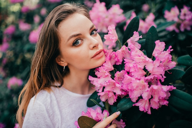 Giovane bella ragazza in posa tra l'albero in fiore