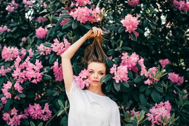 Giovane bella ragazza in posa tra l'albero in fiore