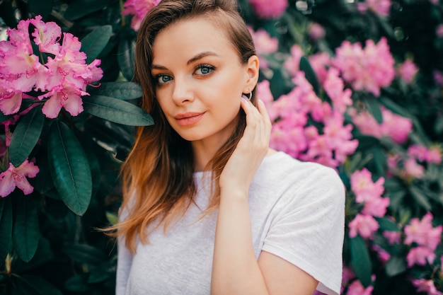 Giovane bella ragazza in posa tra l'albero in fiore