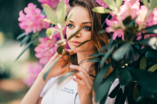 Giovane bella ragazza in posa tra l'albero in fiore