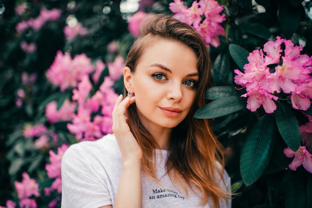 Giovane bella ragazza in posa tra l'albero in fiore