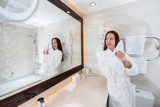 Giovane bella ragazza in un bel bagno bianco. Buongiorno fresco in hotel.