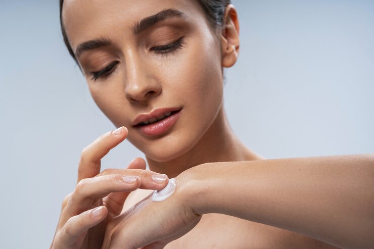 Foto giovane bella signora che applica la crema sulla mano