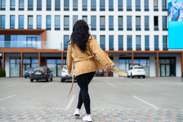 Giovane bella signora nel parco a piedi Donna attraente alla moda in strada della città europea