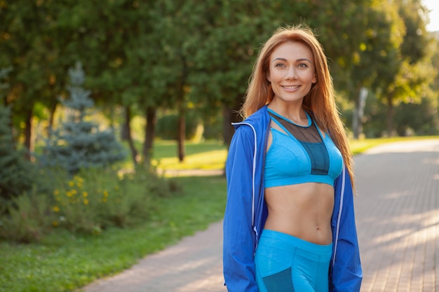 Giovane bella sportiva che funziona nel parco