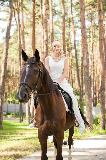 Giovane bella sposa e cavallo sulla natura