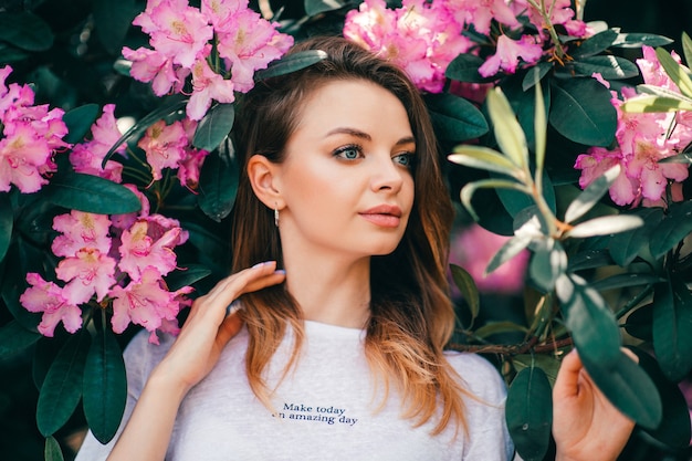 Giovane bella womanposing tra l'albero in fiore