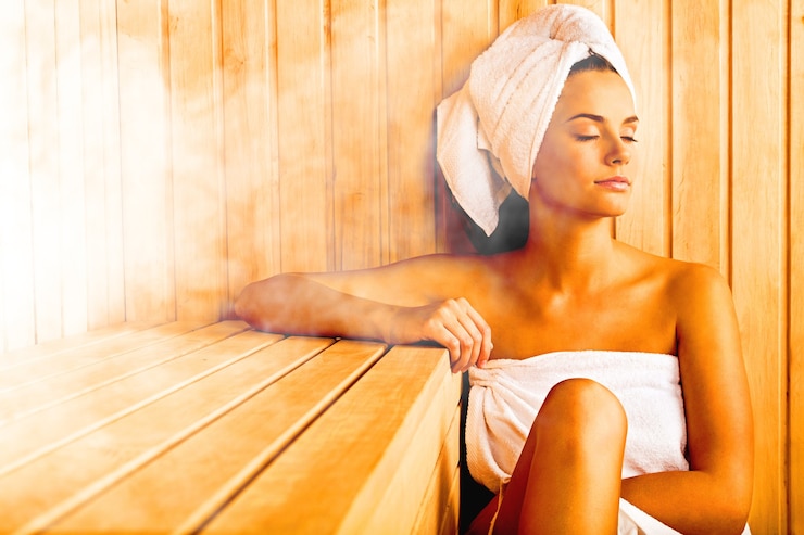 Foto giovane bellissima donna che si rilassa nella sauna