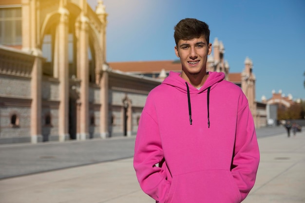 Giovane bello con maglione rosa all'esterno