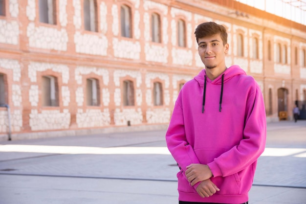 Giovane bello con maglione rosa all'esterno