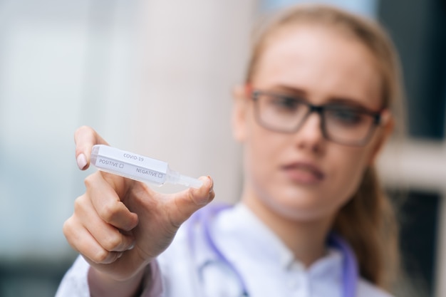 Giovane bello medico che tiene un vaccino