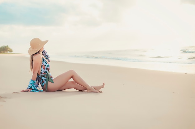 Giovane bello modello sulla sabbia della spiaggia.