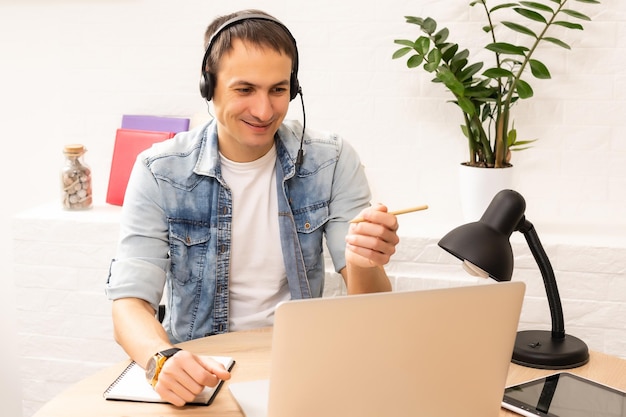 Giovane bello online utilizzando un computer portatile