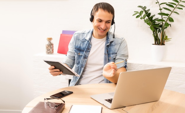 Giovane bello online utilizzando un computer portatile