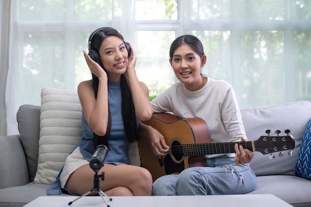 Giovane blogger vlogger di coppia lesbica asiatica e influencer online che registra contenuti video musicali.